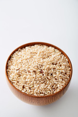Brown rice in a bowl isolated on a white background. Natural organic raw 