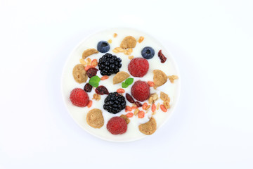 Yogurt con frutti di bosco e cereali su sfondo bianco. Vista dall'alto