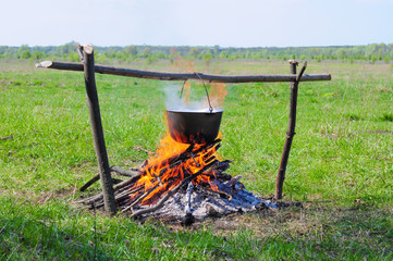 field lunch in a cauldron on a fire in the forest for travel