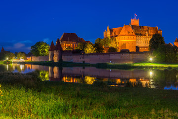 Naklejka na ściany i meble Malbork castle over the Nogat river at night, Poland