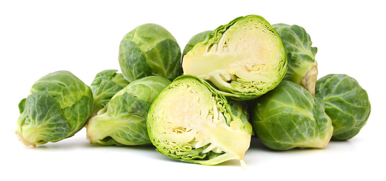 freshly brussel sprouts and some whole ones on a white background