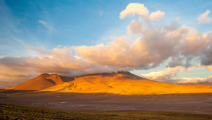 Fototapeta na wymiar Sunset light on volcanos of Atacama Desert. Mountains southern from San Pedro de Atacama. Stunning scenery in evening sunlight at Atacama desert, Chile, South America