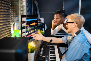 Young musicians looking at computer screen during discussion of sound waveforms