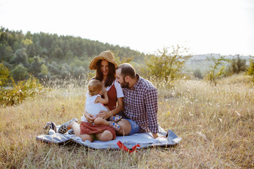 Beautiful family spending time on a field at sunset.