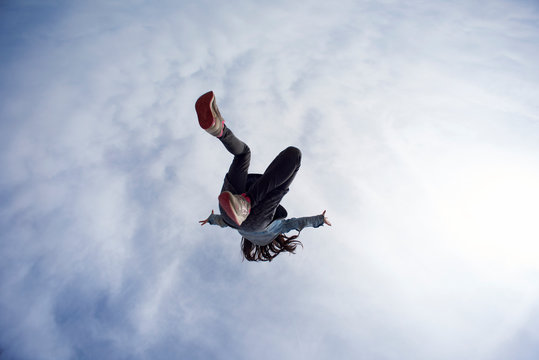 Young Girl Jumping High Into The Sky, Shot From Underneath