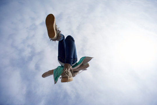 Young Girl Jumping High Into The Sky, Shot From Underneath