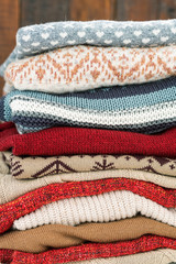Knitted sweaters of various colors with ornaments ready for autumn and winter