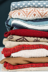 Stack of new woolen and cotton sweaters and jumpers prepared for cold days
