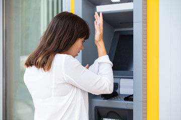 Fototapeta na wymiar Stressed Woman Looking At Her Bank Account Balance At ATM