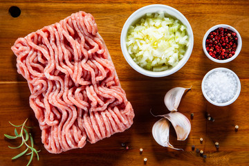 Raw minced pork on cutting board and vegetables