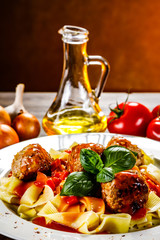 Pasta with meatballs on wooden background