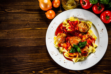 Pasta with meatballs on wooden background