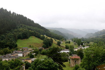 Village and mountains with gray sky, fog and rain