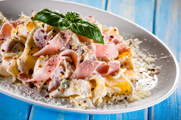 Pasta carbonara on white plate on wooden table
