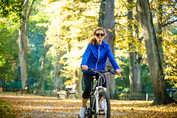 Obraz premium Urban biking - woman riding bike in city park