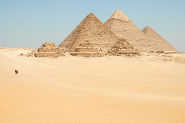 Fototapeta na wymiar Horse drawn carts near Giza pyramids. Khufu, Khafre, Menkaure and pyramids Queens