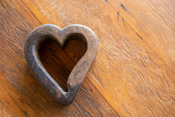 Heart-shaped wooden closeup on rustic wooden table in farm with copy space. Concept of shape, backgrounds, warning, sign, crafts, decoration, design, art and colors.