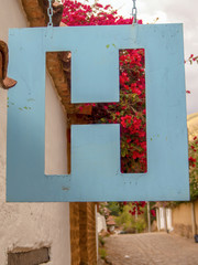 Close-up photography of a hanging metallic hotel signal. Photographed at a street of the colonial town of Villa de Leyva, in the central Andean mountains of Colombia.