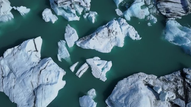 Spinning aerial top view of icebergs at Jokulsarlon glacier lagoon