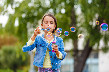 Little girl blowing soap bubbles