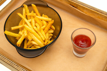 Golden French fries potatoes ready to be eaten. French fries with ketchup on white background.