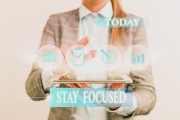 Word writing text Stay Focused. Business photo showcasing Be attentive Concentrate Prioritize the task Avoid distractions Female human wear formal work suit presenting presentation use smart device