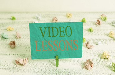 Word writing text Video Lessons. Business photo showcasing Online Education material for a topic Viewing and learning Green clothespin white wood background colored paper reminder office supply