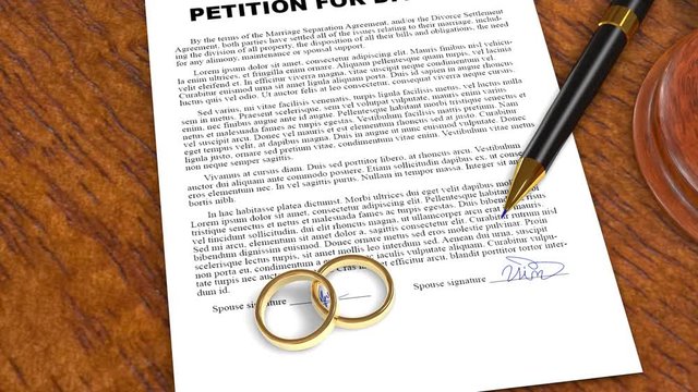 Petition for Divorce signed document with rings on judge table official break up