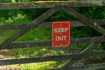 Keep out sign on wooden fence