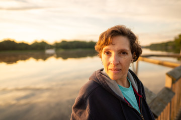 Fototapeta premium Wide angle shot of an older woman at sunrise