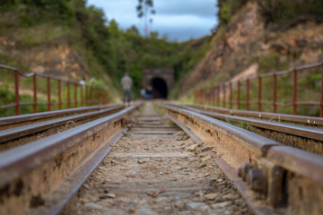 Fototapeta premium Perspective view of train tracks that goes over the Teatinos river, in the highlands of the Andean mountains of central Colombia.