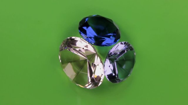 Rotation of a three transparent rhinestone on a green screen.