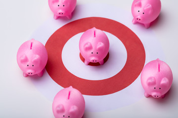 Piggy Bank And Red Darts Target On Desk