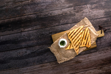 Top view on set of tortilla quesadillas with turkey, mushrooms and souce on wooden background. Healthy food concept in rustic style with copy space