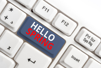 Writing note showing Hello Spring. Business concept for Welcoming the season after the winter Blossoming of flowers White pc keyboard with note paper above the white background