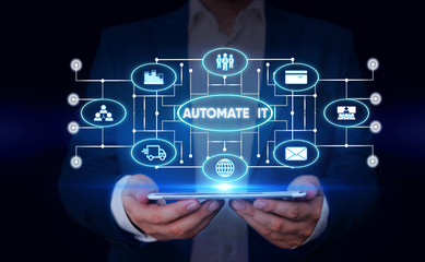 Writing note showing Automate It. Business concept for convert process or facility to be operated automatic equipment. Male wear formal suit presenting presentation smart device