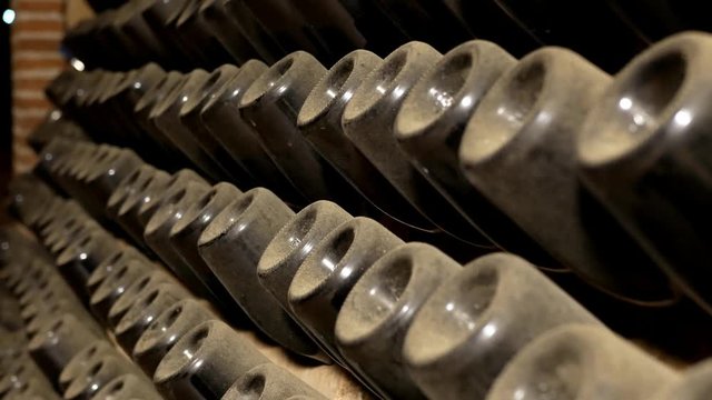 Pupitres with dusty cava bottles in cellar.