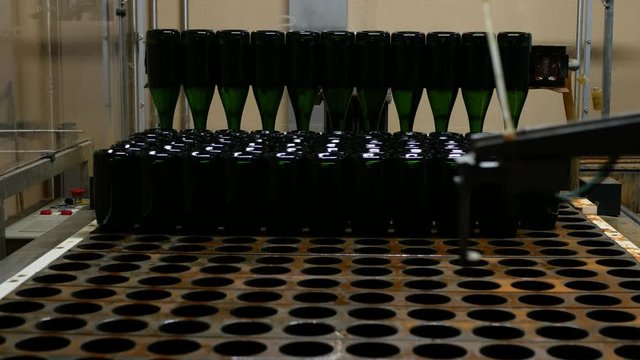 Champagel filling bottles in bottling line in a cava winery.