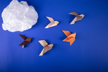 Migration of birds concept of autumn handmade origami birds fly away from the cold on a paper...