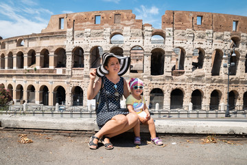 Obraz premium Young Mother And Daughter Sitting In Front Of Colosseum