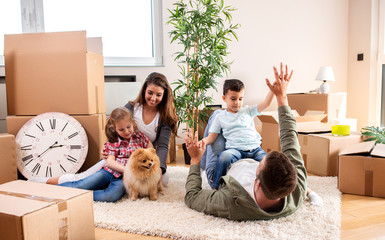 Mom, dad, their kids and their dog moving in the new apartment and having fun