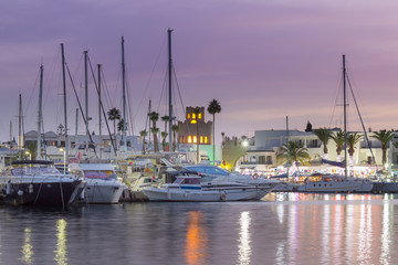 Amazing marina in Port El Kantaoui, Tunisia, colorful blue hour sky, reflections in the sea and beautiful yachts and white villas and hotels