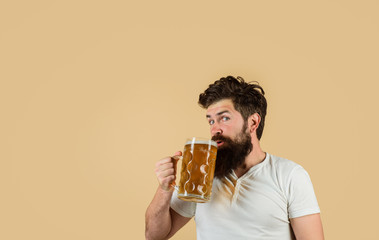 Bearded man drinking beer from glass at bar or pub. Craft beer at restaurant. Oktoberfest festival. Drink, alcohol, leisure and people concept. Bearded male tasting fresh brewed beer. Beer in Germany.