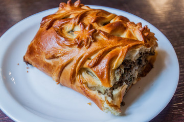 Piece of  Pirozhki (pirog) pie in a restaurant in Minsk, Belarus