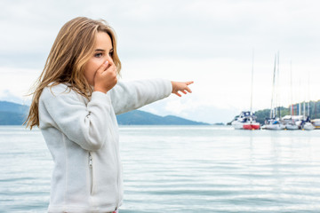 Standing child girl expresses diverse faces of surprise and curiosity.