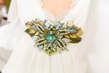 Flower shaped brooch made with small gemstones for a wedding dress.