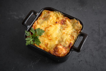 Risotto with meat and vegetables baked under cheese crust decorated with figs