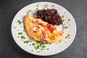 Healthy breakfast. Omelette from eggs, ham and vegetables.