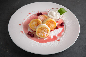 Healthy breakfast. Curd cheese cakes with sugar powder and cherry syrup