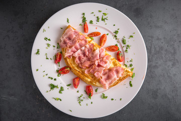 Healthy breakfast. Omelette from eggs, ham and vegetables.